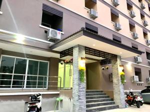 a house with a green door and a building at MY HOME Hotel - Phutthamonthon 4 Road, near Mahidol University Salaya in Ban Krathum Lom