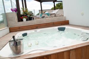 a bath tub with wine glasses in it on a balcony at Sicilia's Art Hotel & Spa in Acitrezza