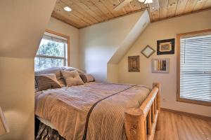 een slaapkamer met een bed in een kamer met een raam bij Lovely Pine Mountain Club Retreat with Hot Tub! in Pine Mountain Club