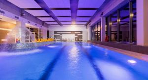 a swimming pool with a fountain in a building at Onyx Aquamarina by Baltico Apartament in Międzyzdroje