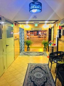 a lobby with a hallway with a table and a rug at HALA HOTELS APARTMENTS in Sharjah