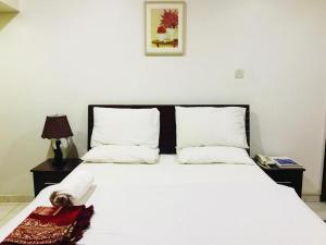 a bedroom with a white bed with a dog laying on it at HALA HOTELS APARTMENTS in Sharjah