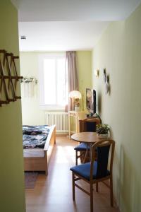 a room with a table and a bed and a table and chairs at Quartier Goldener Löwe in Günthersleben