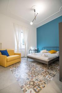 a bedroom with two beds and a yellow couch at Qu4ttro I Salerno 1950 in Salerno