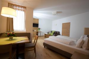 a bedroom with a bed and a table and a dining room at Berglife Appartements in Serfaus
