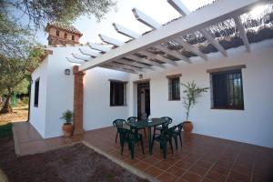 a patio with a table and chairs under a pergola at Casa Rural La Serrana de Aracena in Aracena