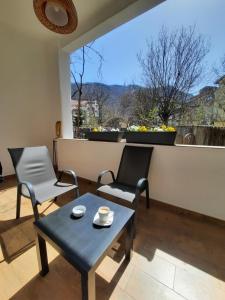a living room with a table and chairs and a window at PIF Apartments Sadoveanu in Braşov