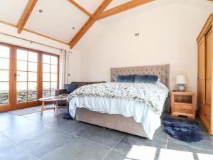 a bedroom with a bed and a couch and windows at Rosewarrick Cottage in Bodmin