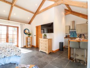 a bedroom with a bed and a kitchen at Rosewarrick Cottage in Bodmin