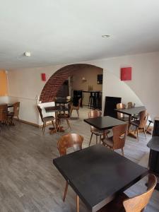 a dining room with tables and chairs and a fireplace at La chaumiere in Seyne