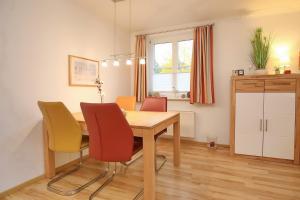 a dining room with a wooden table and chairs at Feriendorf Papillon Wohnung 03-1 in Boltenhagen