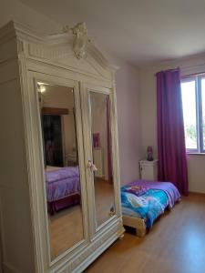 Monclar-de-QuercyにあるRelais de la posteのベッドルーム(鏡、ベッド付)