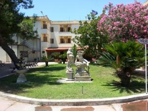 a statue in the grass in front of a building at Hotel Park Jonio in Steccato