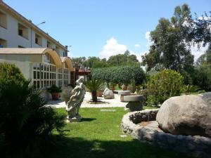 a garden with a statue in front of a building at Hotel Park Jonio in Steccato