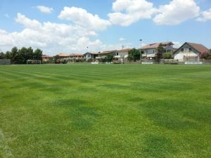 a large field of green grass with houses in the background at Hotel Park Jonio in Steccato