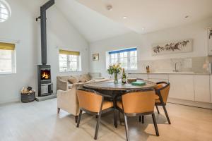 cocina y sala de estar con mesa y sillas en Red Kite Cottage, en Petersfield