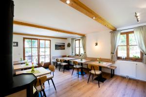 a dining room with tables and chairs and windows at Weinberghof Ilkerl-Luf in Krems an der Donau