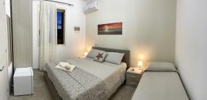 Habitación blanca con cama y ventana en Il profumo del mare, en Marina di Mancaversa