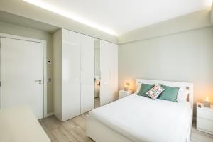 ein weißes Schlafzimmer mit einem weißen Bett und einer Tür in der Unterkunft Blue Star Luxury Apartment by Atlantic Places in Albufeira