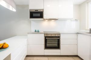 eine weiße Küche mit weißen Schränken und einem Herd in der Unterkunft Blue Star Luxury Apartment by Atlantic Places in Albufeira + 12 Fotos