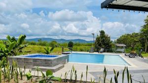 Una piscina en un patio con montañas al fondo. en ORIGEN FINCA HOTEL, en Quimbaya