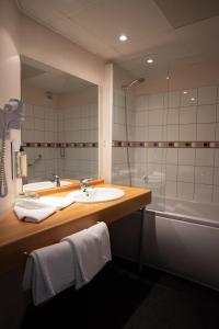 La salle de bains est pourvue d'un lavabo, d'une douche et d'un miroir. dans l'établissement The Originals Boutique, Actuel Hôtel, Saint-Etienne Aéroport, à Andrézieux-Bouthéon