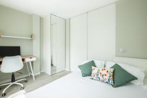 ein Schlafzimmer mit einem Bett mit einem Schreibtisch und einem Stuhl in der Unterkunft Blue Star Luxury Apartment by Atlantic Places in Albufeira
