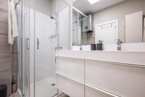 ein weißes Badezimmer mit Dusche und Waschbecken in der Unterkunft Blue Star Luxury Apartment by Atlantic Places in Albufeira