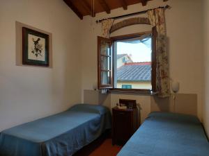 a bedroom with two beds and a window at CASA PARTINGOLI in Pian dei Cerri