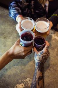 un grupo de personas sosteniendo tres vasos de cerveza en Yes Lisbon Hostel en Lisboa