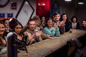 un grupo de personas sentadas en un bar saludando en Yes Lisbon Hostel, en Lisboa