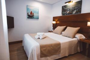 um quarto com uma cama com duas toalhas em Ferreira Hostal Boutique em Conil de la Frontera