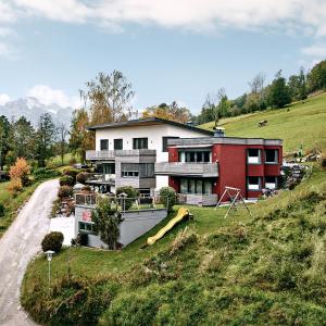 a house on the side of a hill with a slide at Bergleben Maria Alm - Haus Panorama in Maria Alm am Steinernen Meer