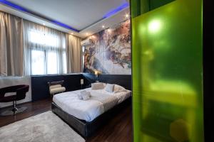 a bedroom with a bed and a painting on the wall at Gallery Art Hotel in Tríkala