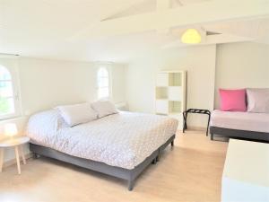 ein weißes Schlafzimmer mit einem Bett und einem Tisch in der Unterkunft Le Gîte du Petit Plessis in Saint-Viaud