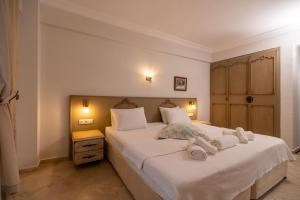 a bedroom with a large white bed with towels on it at B&B Boutique Hotel in Dalyan