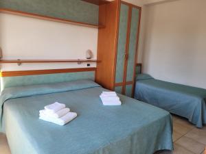 2 posti letto in camera con asciugamani di HOTEL ADRIA BEACH a Rimini