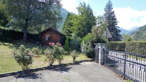 une porte menant à une maison dotée d'une clôture et de fleurs dans l'établissement Villa 180 m² proche 3 vallées et station thermale, à Champoulet