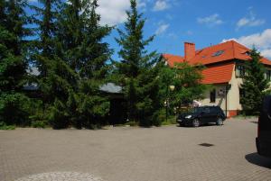 a car parked in a parking lot in front of a house at Pensjonat U Kota Wasyla in Chodzież