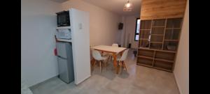 a small kitchen with a table and a refrigerator at Depto Temporario La Plata in La Plata