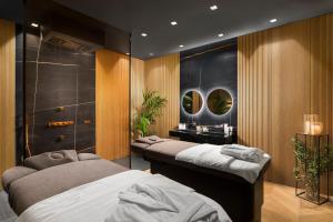 a bedroom with two beds and a bathroom with mirrors at Lure Hotel & Spa - Adults Only in Mellieħa