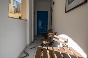 a balcony with two benches and a blue door at Ada Hotel in Giardini Naxos