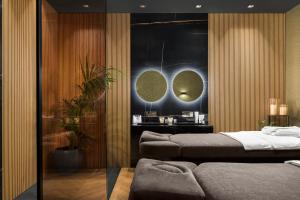 a bedroom with two beds and two mirrors at Lure Hotel & Spa - Adults Only in Mellieħa