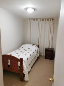 Un dormitorio con una cama en una habitación con ventana. en Depto Maqui, en Puerto Montt
