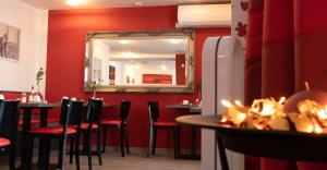 a restaurant with red walls and a mirror and chairs at Hotel Freihof in Stuttgart