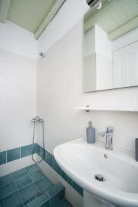 Baño blanco con lavabo y espejo en SERIFOS BELLA VISTA 1 en Livadi