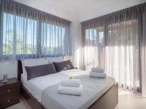 1 dormitorio con 1 cama grande y toallas. en Luxurious Villa David, en Áno Kalésia