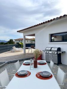 - une table et des chaises blanches sur la terrasse dans l'établissement Villa U Pastore, à Porticcio
