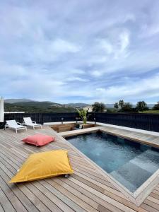 eine Terrasse mit einem Pool auf dem Dach eines Hauses in der Unterkunft Villa U Pastore in Porticcio