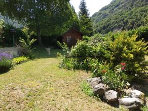 a garden with flowers and a cabin in the background at Villa 180 m² proche 3 vallées et station thermale in Champoulet